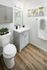 Contemporary bathroom with elegant cabinetry, stylish sink, sleek toilet, and modern decor.
