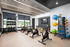 Modern fitness room with sleek exercise bikes, vibrant exercise balls, and natural light from large windows.
