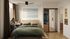 Cozy bedroom featuring a comfortable bed with green bedding, an open closet, and a desk by the window with abundant natural light.