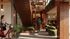 Modern interior showcasing a warm wooden staircase, lush greenery, and stylish seating area with hanging lights, creating an inviting communal space.