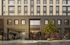 Chic urban apartment complex with a modern facade, featuring a welcoming entrance and vibrant street scene.