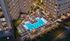 Luxurious apartment complex with a stunning pool area, lounge chairs, and landscaped gardens, perfect for relaxation and entertainment.