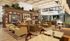 Elegant and inviting communal lounge featuring modern seating, a stylish wooden bookshelf, and abundant natural light.