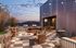 Chic rooftop terrace with modern seating, cozy fire pit, and enchanting string lights at dusk.