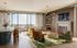 Luxurious living room with floor-to-ceiling windows, modern d&eacute;cor, and a breathtaking city view, featuring a stylish lounge area and dining space.