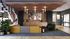 Modern lounge area with vibrant seating, artistic wall design, and a large flat-screen TV, perfect for relaxation and entertainment.