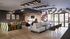Modern communal area with chic seating, stylish lighting, and a vibrant wall design, perfect for gatherings.