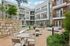 Charming apartment complex courtyard featuring modern balconies, cozy seating areas, and lush greenery for relaxation.