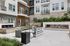 Modern apartment complex courtyard featuring sleek outdoor seating, a stylish fire feature, and contemporary water fountain.