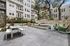 Modern outdoor patio space in luxurious apartment complex, featuring elegant seating, tasteful landscaping, and contemporary architectural design.