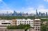 Stunning apartment view with lush greenery and a vibrant city skyline as the backdrop.