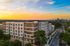 Modern apartment building, The Mercury, with stunning sunset backdrop and city skyline views.