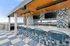Chic rooftop bar with blue mosaic tiles, stylish seating, and city skyline views.