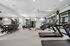 Modern home gym with state-of-the-art equipment, including treadmills, weights, and exercise bikes, in a bright and spacious room with mirrored walls and natural light.