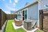 Charming backyard patio with modern outdoor seating and privacy fence, ideal for relaxation and entertainment.