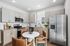 Modern kitchen featuring stainless steel appliances, sleek cabinetry, and a cozy dining area with stylish leather chairs.