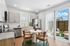 Modern kitchen with granite countertops, stainless steel appliances, and cozy dining area opening to a stylish outdoor patio.