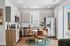 Modern kitchen with sleek appliances, elegant cabinetry, and a cozy dining area featuring stylish leather chairs.