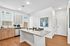 Modern kitchen with sleek granite countertops, stylish wooden cabinets, and vibrant artwork, creating an inviting ambiance.