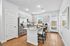 Modern kitchen with sleek stainless steel appliances, an elegant granite island, and bright natural light streaming through large windows.