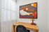 Chic home office nook featuring a wooden desk, stylish abstract art, and soft natural light.