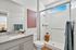 Modern bathroom with elegant granite countertop, sleek shower, and stylish decor, offering a serene and luxurious ambiance.