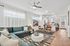 Inviting open-plan living area featuring a modern sectional couch, elegant decor, and a sleek kitchen with a breakfast bar.