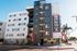 Modern urban apartment building with stylish facade, showcasing a vibrant and welcoming entrance, perfect for contemporary living.