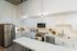 Modern kitchen with sleek stainless steel appliances, elegant white cabinetry, and chic pendant lighting for a stylish cooking space.