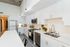 Modern kitchen with sleek white cabinetry, stainless steel appliances, and a spacious island. Contemporary lighting and minimalist style create a bright, inviting atmosphere, perfect for culinary adventures.