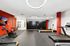 Modern fitness center featuring state-of-the-art equipment, sleek red brick details, and elegant circular lighting.