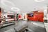 Sleek, modern fitness center with state-of-the-art equipment, ambient lighting, and vibrant red accents, perfect for energizing workouts.