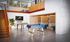 Modern loft-style apartment with vibrant orange staircase, foosball table, stylish seating booths, and artistic wall decor.