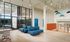 Contemporary lobby space with sleek blue couches, modern pendant lighting, and vibrant accents, exuding a welcoming and stylish ambiance.