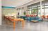 Vibrant open-concept co-working space featuring contemporary furniture, large windows with natural light, and colorful seating arrangements.