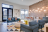 Chic communal living area featuring modern seating, vibrant decor, and a cozy dining space with hanging lights.