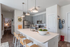 Modern kitchen with sleek gray cabinetry, stainless steel appliances, and a spacious breakfast bar with stylish pendant lighting.