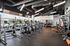 Modern fitness center with state-of-the-art equipment, large windows, and motivational decor, offering a vibrant workout environment.