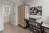 Contemporary home office featuring a sleek desk, modern chair, and organized pinboard, adjacent to a stylish bathroom with natural wood finishes.