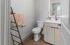 Bright and modern bathroom featuring sleek fixtures, a stylish mirror, and a wooden vanity with ample storage space.