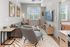 Modern living room with stylish decor, cozy gray sofa, abstract art, and large wall-mounted TV, offering a comfortable and inviting space.
