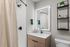 Modern bathroom featuring a sleek vanity with illuminated mirror and elegant shower design.