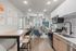 Modern apartment interior featuring a stylish open-concept kitchen and living room, with sleek appliances, cozy seating, and contemporary artwork.