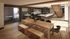 Modern open-concept kitchen and dining area with sleek countertops, wooden dining table, and ambient lighting.