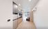 Modern apartment interior showcasing a sleek kitchen with stainless steel appliances, elegant cabinetry, and a cozy living area filled with natural light.