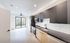 Modern open-concept kitchen and living area with sleek cabinetry, stainless steel appliances, and bright natural lighting.