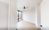 Bright bedroom with large window offering scenic views, elegant wood flooring, and a modern ceiling fan.