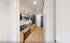 Modern apartment kitchen with sleek appliances, stylish subway tile backsplash, and elegant wood flooring.