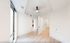 Bright and modern room with sleek hardwood floors, large window, and ceiling fan, adjacent to a bathroom with glass shower.