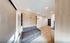Inviting modern living room with sleek wooden floors, a cozy gray sofa, recessed lighting, and built-in cabinetry for stylish storage.